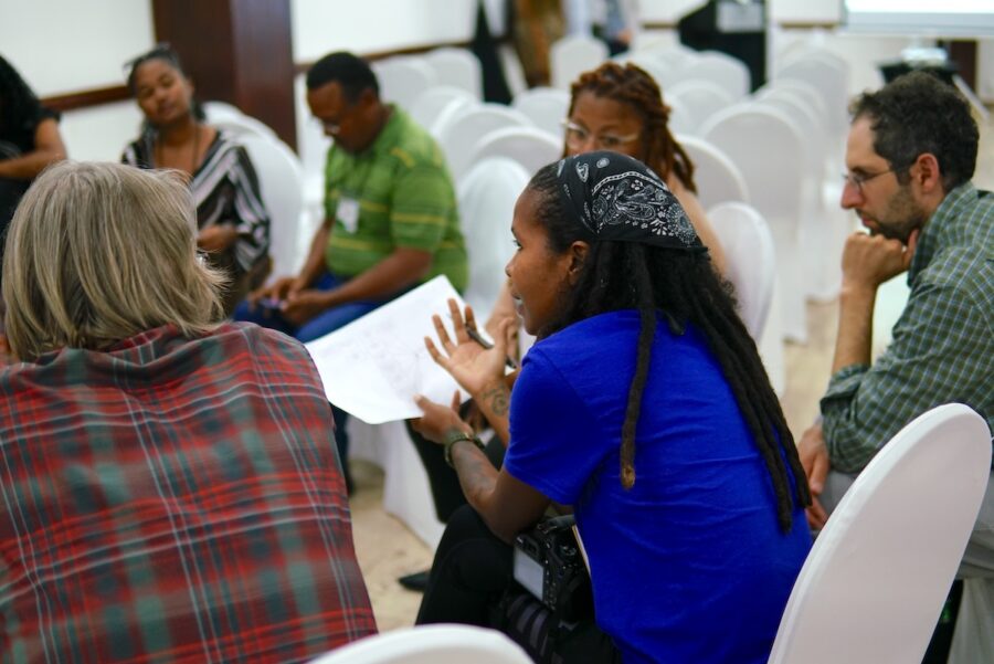 Group of people sitting in a circle and having a discussion.