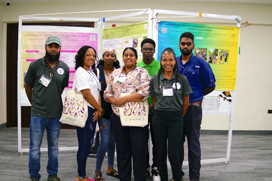 Group of people standing in front of scientific posters.